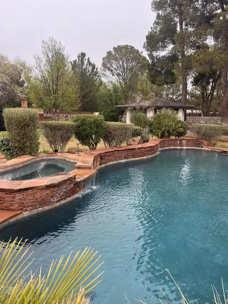 Custom swimming pool with stone water feature and integrated spa